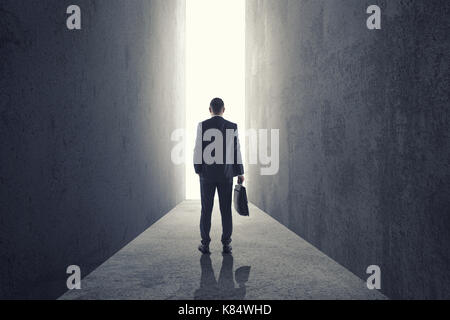 Silhouette of businessman entering giant doorway Stock Photo