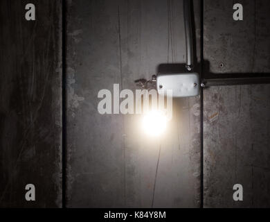 Glowing shinny bright light bulb on old wooden ceiling Stock Photo