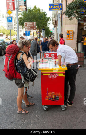 Backpackers at a city guide tour stand in central Budapest, checkin out optional tours. Stock Photo