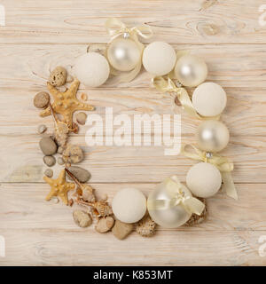 Christmas and New Year. Christmas wreath of Christmas-tree white toys in marine style, shells, stones and starfish. Selective focus. Stock Photo