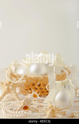 Christmas and New Year. Christmas-tree white toys in a marine style, seashells stones and starfish. Selective focus. Stock Photo