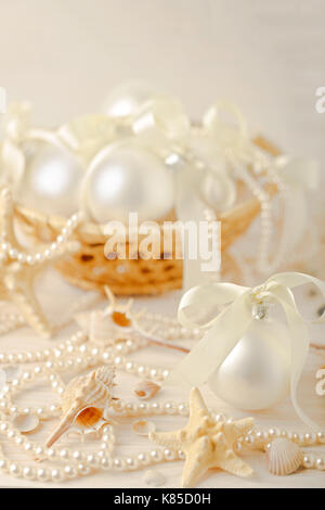Christmas and New Year. Christmas-tree white toys in a marine style, seashells stones and starfish. Selective focus. Stock Photo