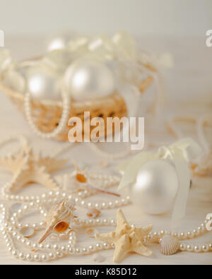 Christmas and New Year. Christmas-tree white toys in a marine style, seashells stones and starfish. Selective focus. Stock Photo