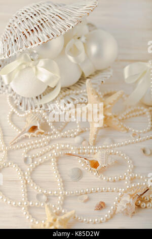 Christmas and New Year. Christmas-tree white toys in a marine style, seashells stones and starfish. Selective focus. Stock Photo