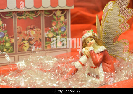 close up of a christmas fairy with various decorations on red background Stock Photo