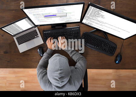 High Angle View Of Hacker Stealing Information From Computers At Desk Stock Photo