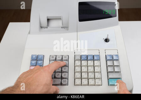 Close-up Of Person Hands Entering Amount On Cash Register Stock Photo