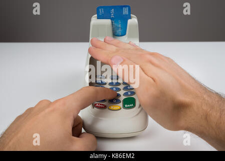 Close-up Of Person Hands Entering Code In A Card Reader Machine Stock Photo