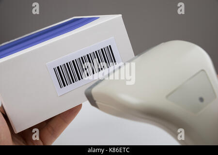 Close-up Of Person Hands Using Barcode Scanner To Scan A Barcode On A Box Stock Photo