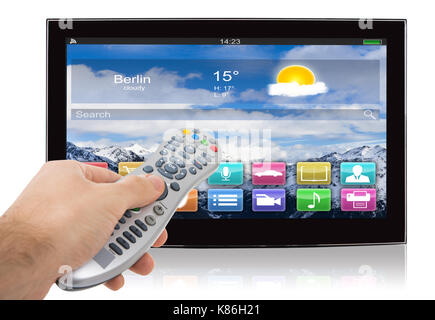 Hand using remote control of smart flat screen television against white background Stock Photo