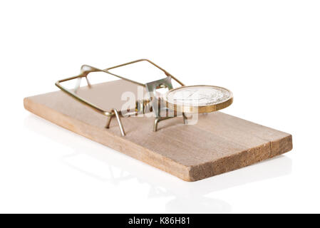 Closeup of coin on mousetrap against white background Stock Photo