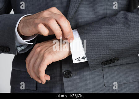 Midsection of businessman removing ace cards from sleeve in office Stock Photo