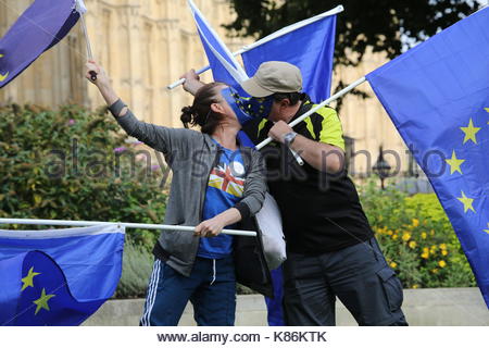 Two masked, kissing EU supporters bearing flags in support of the EU at Westminster. Credit: reallifephotos/Alamy Stock Photo