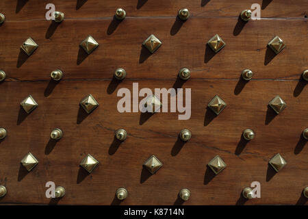 Wooden studded door, with gold studs. Stock Photo