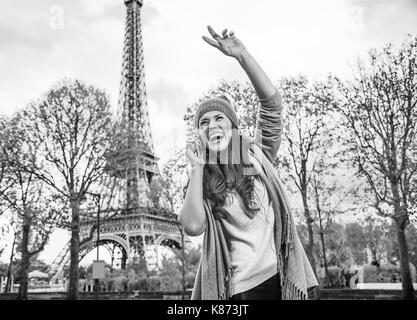 Autumn getaways in Paris. happy young woman in Paris, France using a mobile phone and handwaving Stock Photo