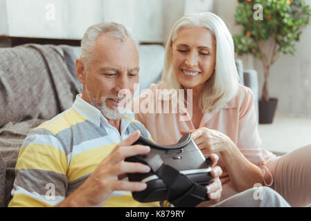 Cheerful aged couple testing VR device Stock Photo