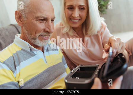 Cheerful retired man testing a VR device with his wife Stock Photo