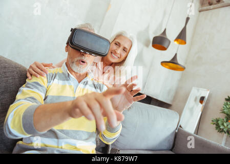 Retired aged man trying up VR glasses Stock Photo
