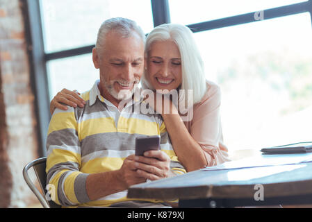 Positive aged couple using their smart phone Stock Photo