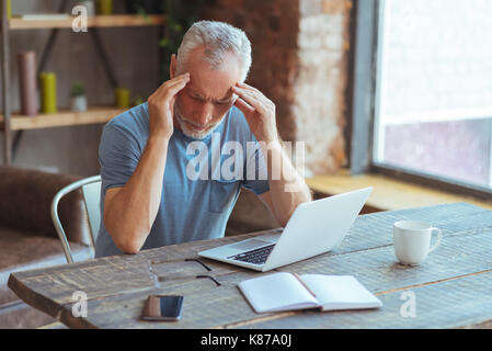 Sick aged man suffering from a headache Stock Photo