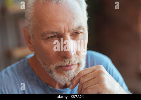Thoughtful elderly man holding his hand on the chin Stock Photo