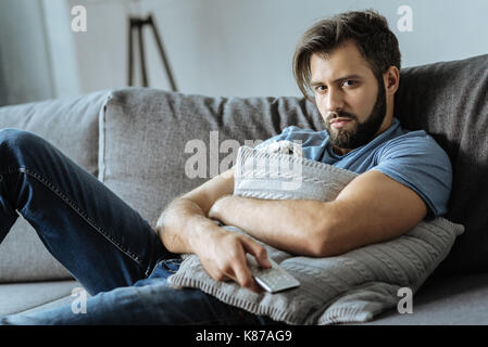 Depressed moody man resting on the sofa Stock Photo