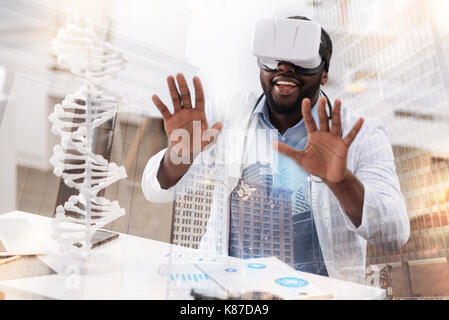 Young pleased doctor wearing virtual reality glasses Stock Photo