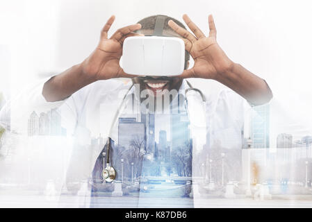 Happy African American doctor wearing virtual glasses Stock Photo