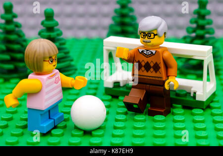Tambov, Russian Federation - September 21, 2016 Lego girl playing football with her grandfather. Focus on grandfather. Studio shot. Stock Photo