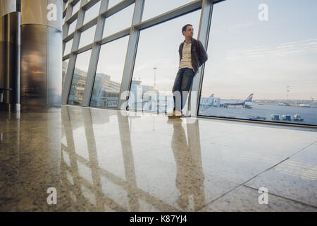 Portrait of an attractive young man walking and looking at mobile phone Stock Photo
