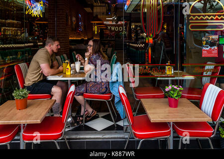A Couple Sitting At A Table In A Restaurant In Kensington High Street, London, UK Stock Photo