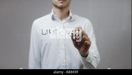 Like us , Man Writing on Glass Stock Photo