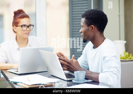 Two home-office workers discussing ideas for new project or making online research Stock Photo