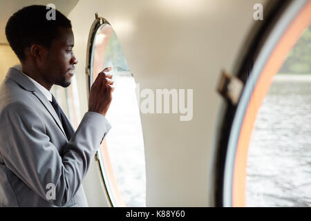 Young businessman in suit going to write something on steamship window Stock Photo