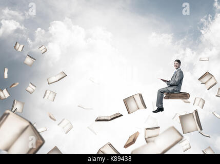 Man reading book and many of them flying in air Stock Photo