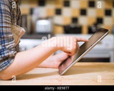 woman using digital tablet in the kitchen Stock Photo