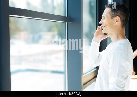 Delighted nice man looking into the window Stock Photo