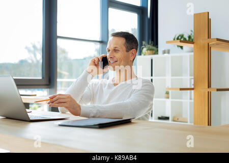 Happy delighted man holding a pencil Stock Photo