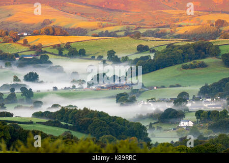 Flintshire, North Wales. A chilly bright start for North Wales with temperatures as low as 3.9C in the village of Lixwm overnight. Morning mist forming in the coldest of areas during sunrise this morning over the rural Flintshire near to the village of Nannerch and the Clwydian Range hills bathed in sunlight Stock Photo