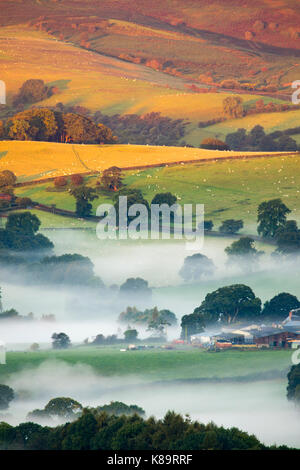 Flintshire, North Wales. A chilly bright start for North Wales with temperatures as low as 3.9C in the village of Lixwm overnight. Morning mist forming in the coldest of areas during sunrise this morning over the rural Flintshire near to the village of Nannerch and the Clwydian Range hills bathed in sunlight Stock Photo