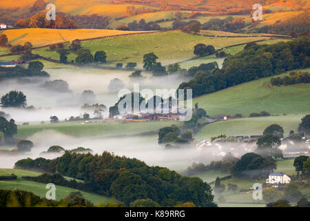 Flintshire, North Wales. A chilly bright start for North Wales with temperatures as low as 3.9C in the village of Lixwm overnight. Morning mist forming in the coldest of areas during sunrise this morning over the rural Flintshire near to the village of Nannerch and the Clwydian Range hills bathed in sunlight Stock Photo