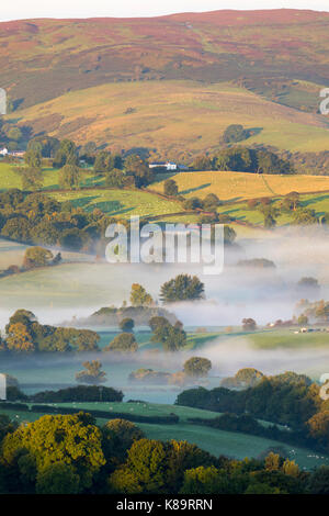 Flintshire, North Wales. A chilly bright start for North Wales with temperatures as low as 3.9C in the village of Lixwm overnight. Morning mist forming in the coldest of areas during sunrise this morning over the rural Flintshire near to the village of Nannerch and the Clwydian Range hills bathed in sunlight Stock Photo