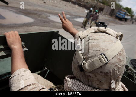 A United States Marine Corps soldier waves to locals in the Grand Barra desert in Djibouti on April 15, 2010. USMC troops joined with the French Forei Stock Photo