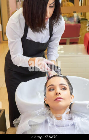 Beautician rinsing hair of client. Stock Photo