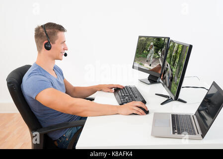 Young Man Playing Game On Computer In House Stock Photo