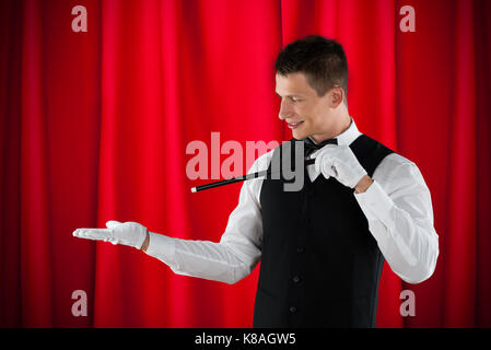 Portrait Of Young Happy Magician Performing Magic Stock Photo