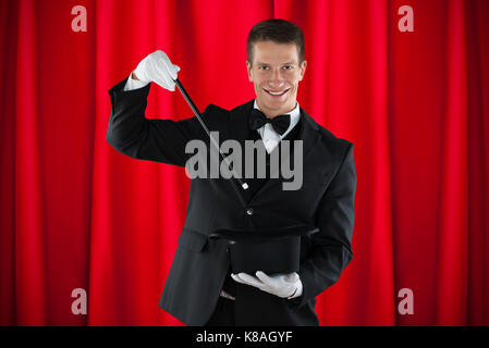 Young Happy Magician Showing Magic Trick With Hat Stock Photo