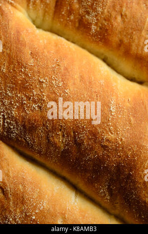 Close up (macro) of the golden brown crust of a freshly baked loaf of white bread. Stock Photo