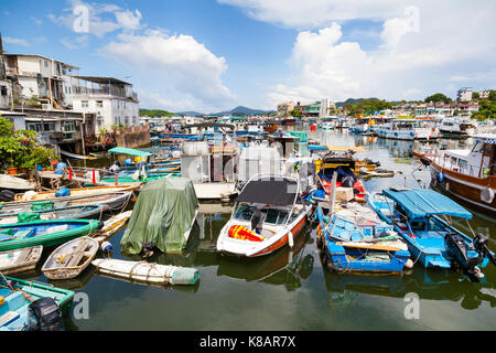 HONG KONG - JULY 13, 2017: Fishing and tour boats dock at the busy harbor in Sai Kung town famous for its quaint fishing villages and the floating sea Stock Photo