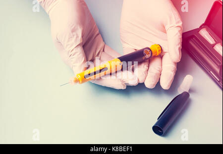 The abbreviation IVF is laid out in wooden letters on a blue background. In  vitro injection pen, tablet and ampoule. A syringe with a thin huge. IVF c  Stock Photo - Alamy